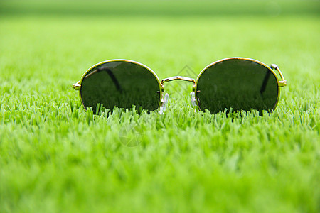 绿茵草坪上的墨镜背景图片