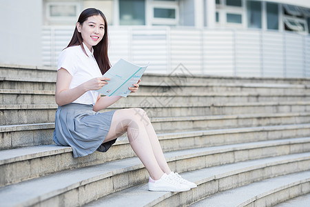 坐在校园台阶上的大学生背景图片