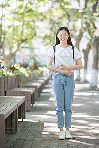 背着书包看书校园里背着书包拿着书的同学背景