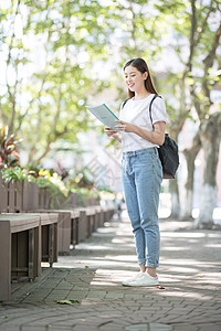 校园里背着书包拿着书的同学图片