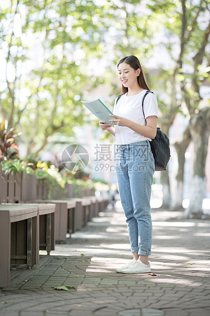 校园里背着书包拿着书的同学图片