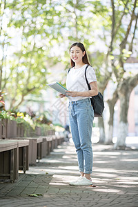 校园里背着书包拿着书的同学图片