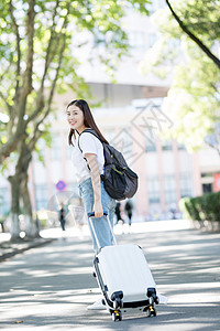 校园里拖着行李箱的女生背景图片