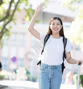 拉着行李箱微笑招手的女生图片