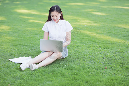 绿色草坪上休闲学习的女生图片