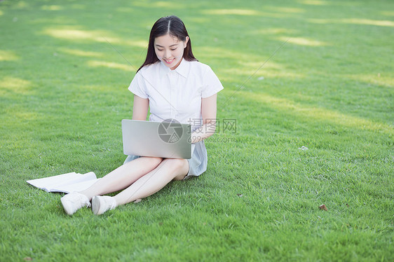 绿色草坪上休闲学习的女生图片