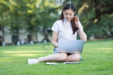 绿色草坪上休闲学习的女生图片