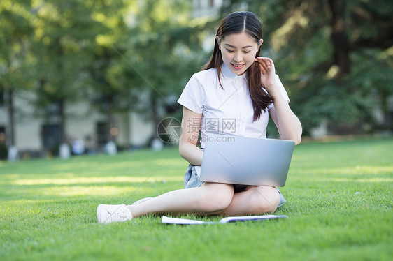 绿色草坪上休闲学习的女生图片