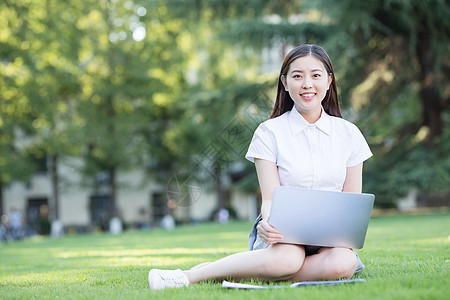 绿色草坪上休闲学习的女生图片