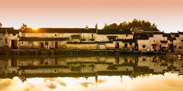 夕阳中的古村和池塘背景图片