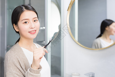 早起洗手间刷牙的年轻 女性图片