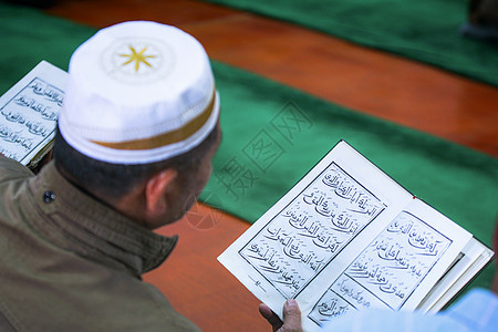 伊斯兰教念古兰经的男性背景图片