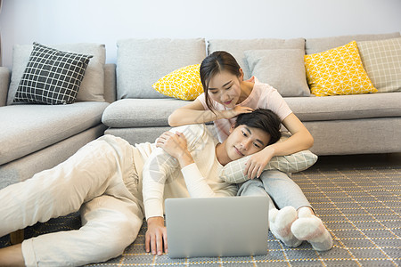 年轻夫妇在客厅看电脑背景图片