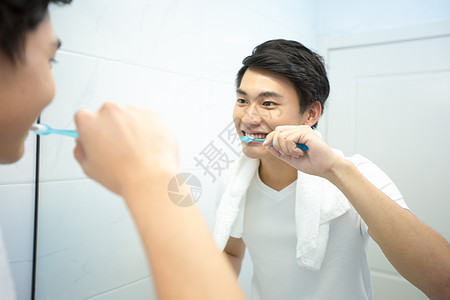 年轻男性在浴室刷牙图片