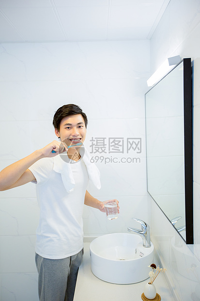 年轻男性在浴室刷牙图片