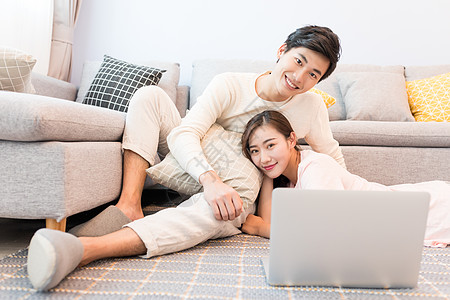 家人客厅看电脑坐在沙发上看电脑的情侣背景