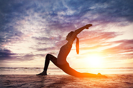 健身的女人在黄昏下锻炼瑜伽设计图片
