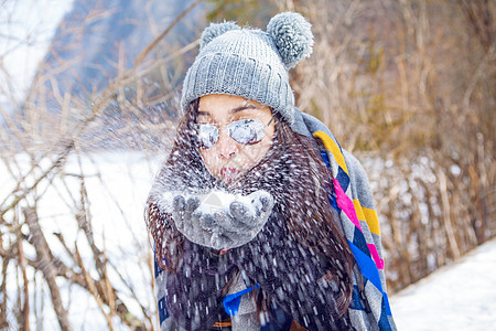 冬季旅游吹雪花的女孩背景