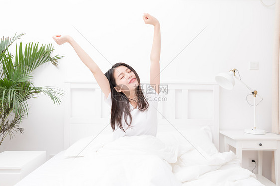 早起起床伸懒腰的年轻女性图片