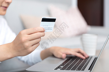 电脑银行卡拿着银行卡使用电脑的男性背景