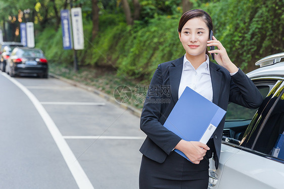 商务女士在车旁打电话图片