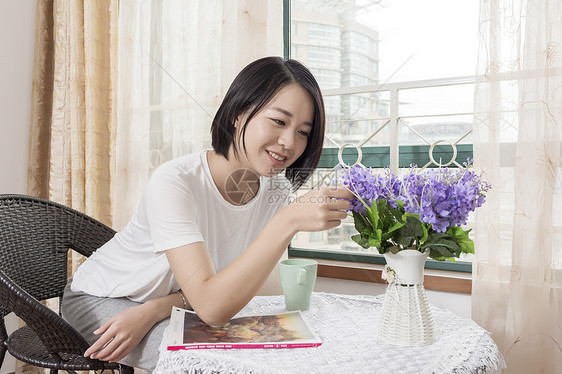 女子在家摆弄花朵图片