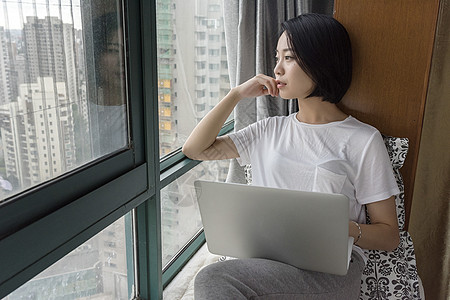 女子坐在飘窗使用电脑图片