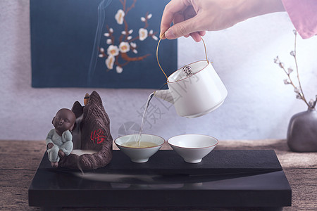 手拿茶壶倒茶背景图片