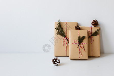 牛皮纸包装盒圣诞礼物摆在白色桌面上背景