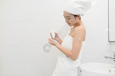 一次性浴帽洗完澡在护肤的年轻美女背景