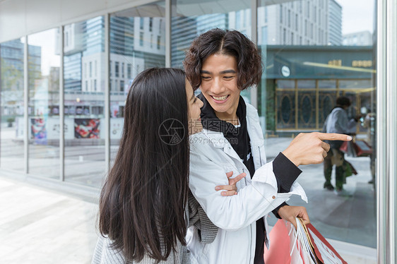 年轻夫妻购物指前方图片