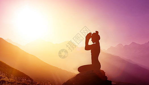 山顶上锻炼瑜伽的女性图片