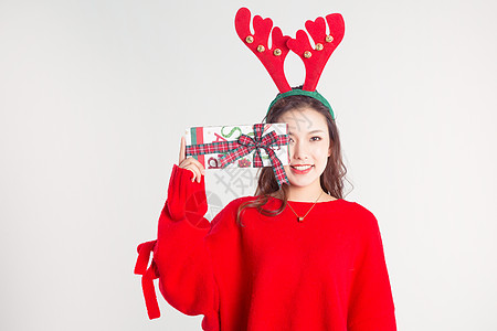 圣诞节人物手拿礼物盒的圣诞装扮女性棚拍背景