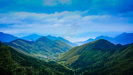 青山绿树蓝天白云下的绿色山脉背景