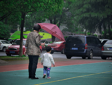 孩子下雨雨中给孩子打伞的妈妈背景
