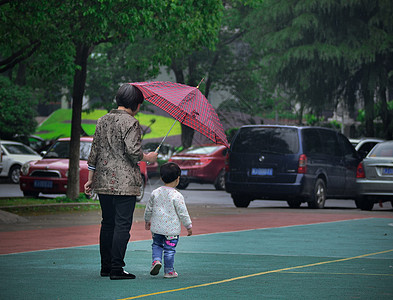 雨中给孩子打伞的妈妈背景图片