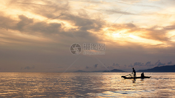 夕阳下海边辛勤劳动的渔民图片