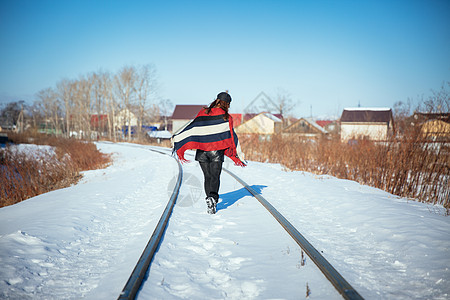 在冬天雪地铁轨上行走的女孩图片