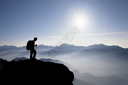 登上山顶俯视群山的人背景图片