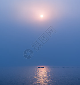 海上日出光影里的渔船高清图片