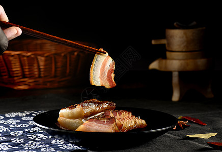 筷子夹切片的烟熏五花腊肉背景