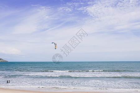 在蓝色海边练习滑翔伞的人背景图片