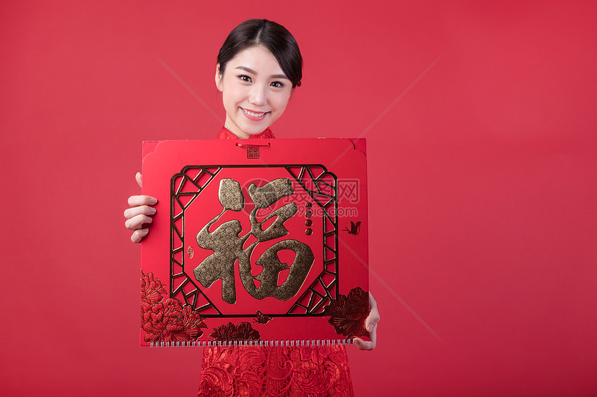 春节穿旗袍的女孩手拿福字图片