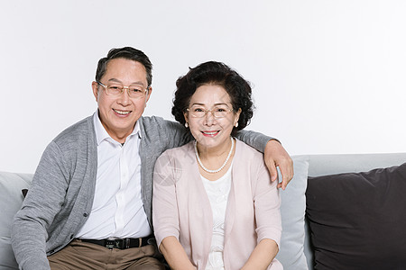 夫妻坐在沙发上坐在沙发上幸福的老年夫妻背景