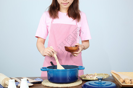 围裙做饭的女人红薯条高清图片