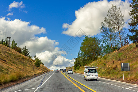 开车旅行蓝天白云下交通繁忙的公路背景