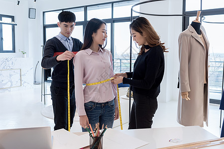 服装设计icon两位设计师给女顾客测量量衣背景
