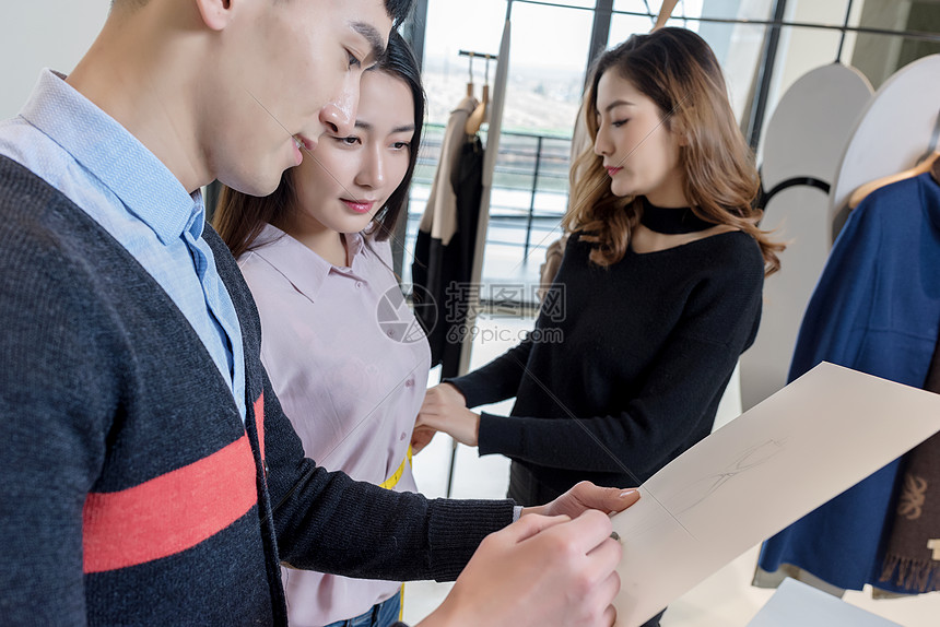 两位设计师给女顾客介绍服装图片