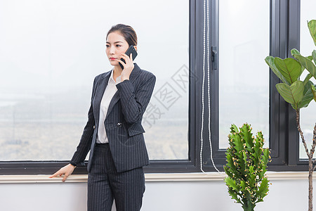 窗前接电话的商务女士图片