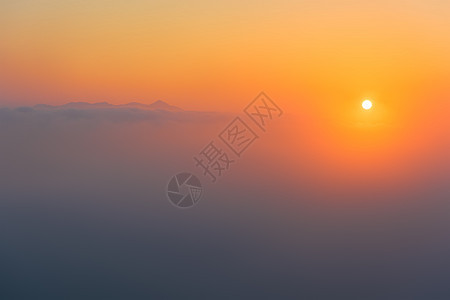 雾气朦胧中的日出与远山图片